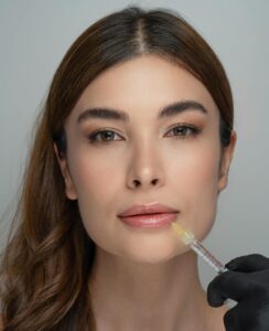 Woman receiving a cosmetic lip injection by a professional in a clinical setting.